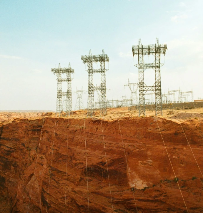Power lines cross a rocky canyon under a blue sky